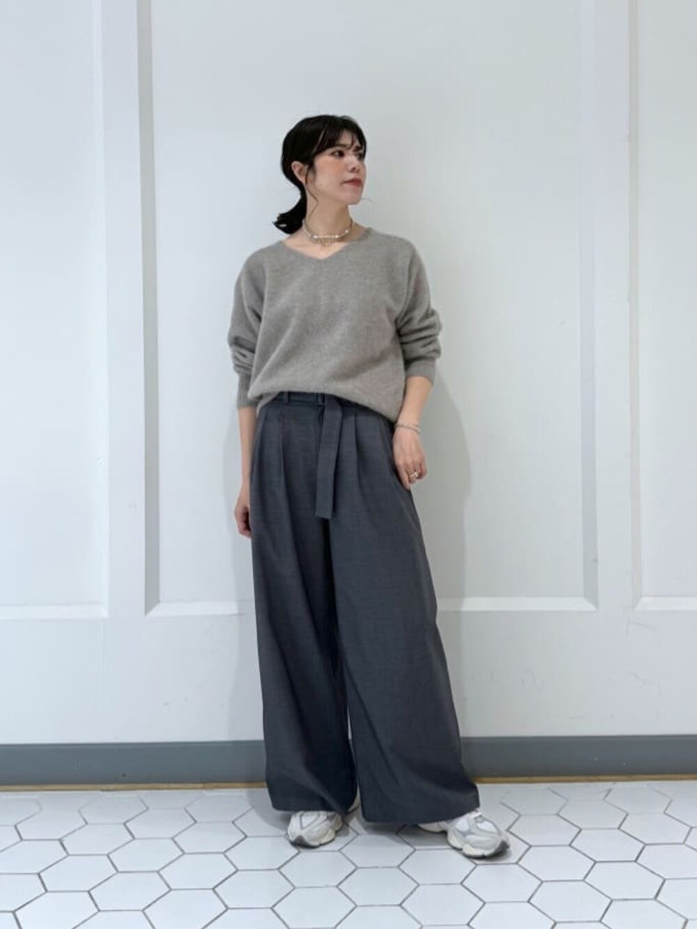 ブラック系のダウンジャケット/コート、グレー系のニット/セーター、グレー系のその他パンツを着用したレディースの冬コーディネートの5枚目の写真