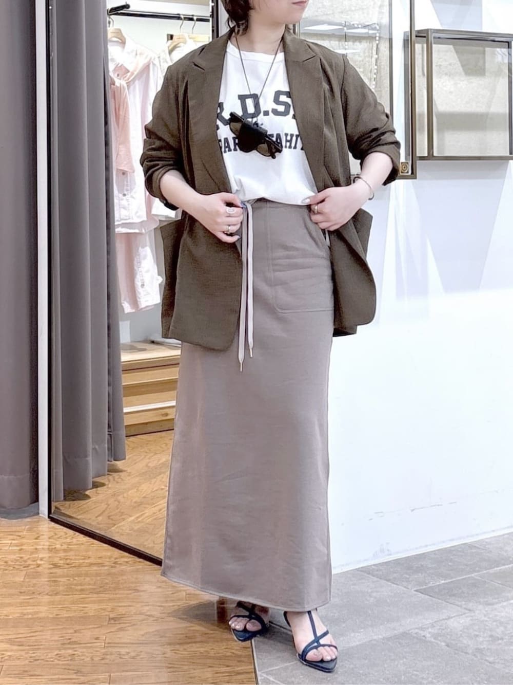 ホワイト系のTシャツ/カットソー、ブラウン系のテーラードジャケット、ブルー系のサンダルを着用したレディースの春コーディネートの6枚目の写真