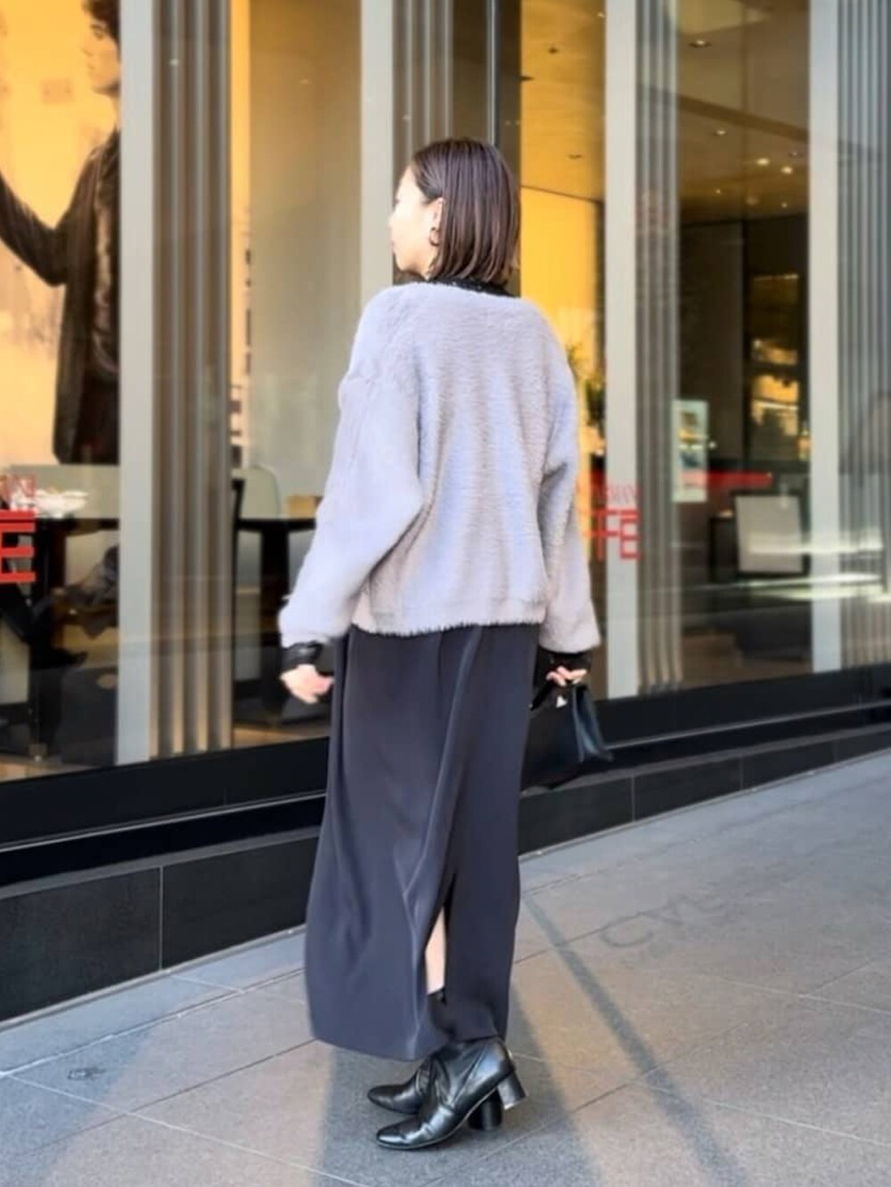 グレー系のカーディガン/ボレロ、ブラック系のワンピース、ブラウン系のブーツを着用したレディースの冬コーディネートの3枚目の写真