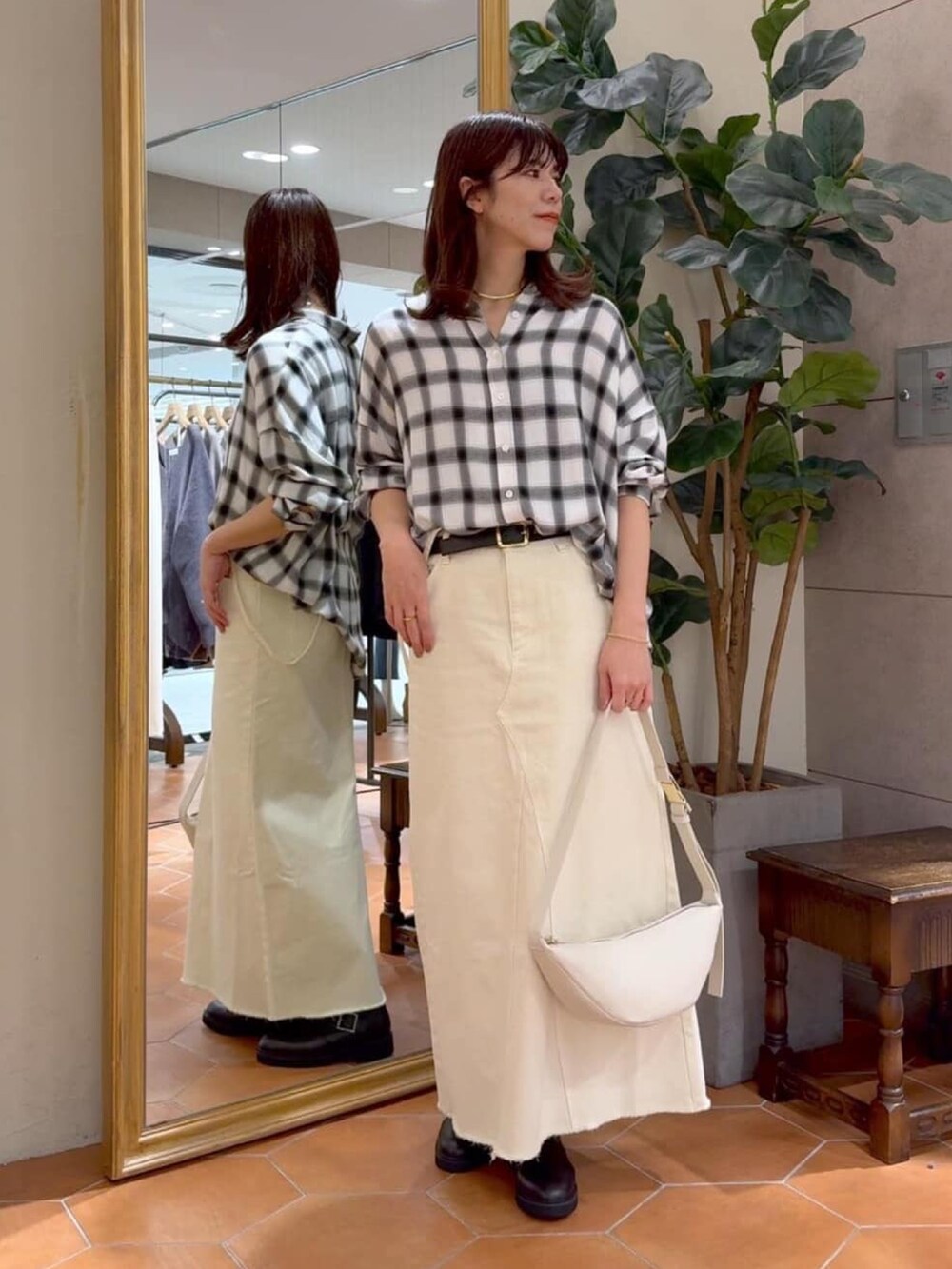 ホワイト系のシャツ/ブラウス、グレー系のマウンテンパーカー、ホワイト系のデニムスカートを着用したレディースの冬コーディネートの4枚目の写真