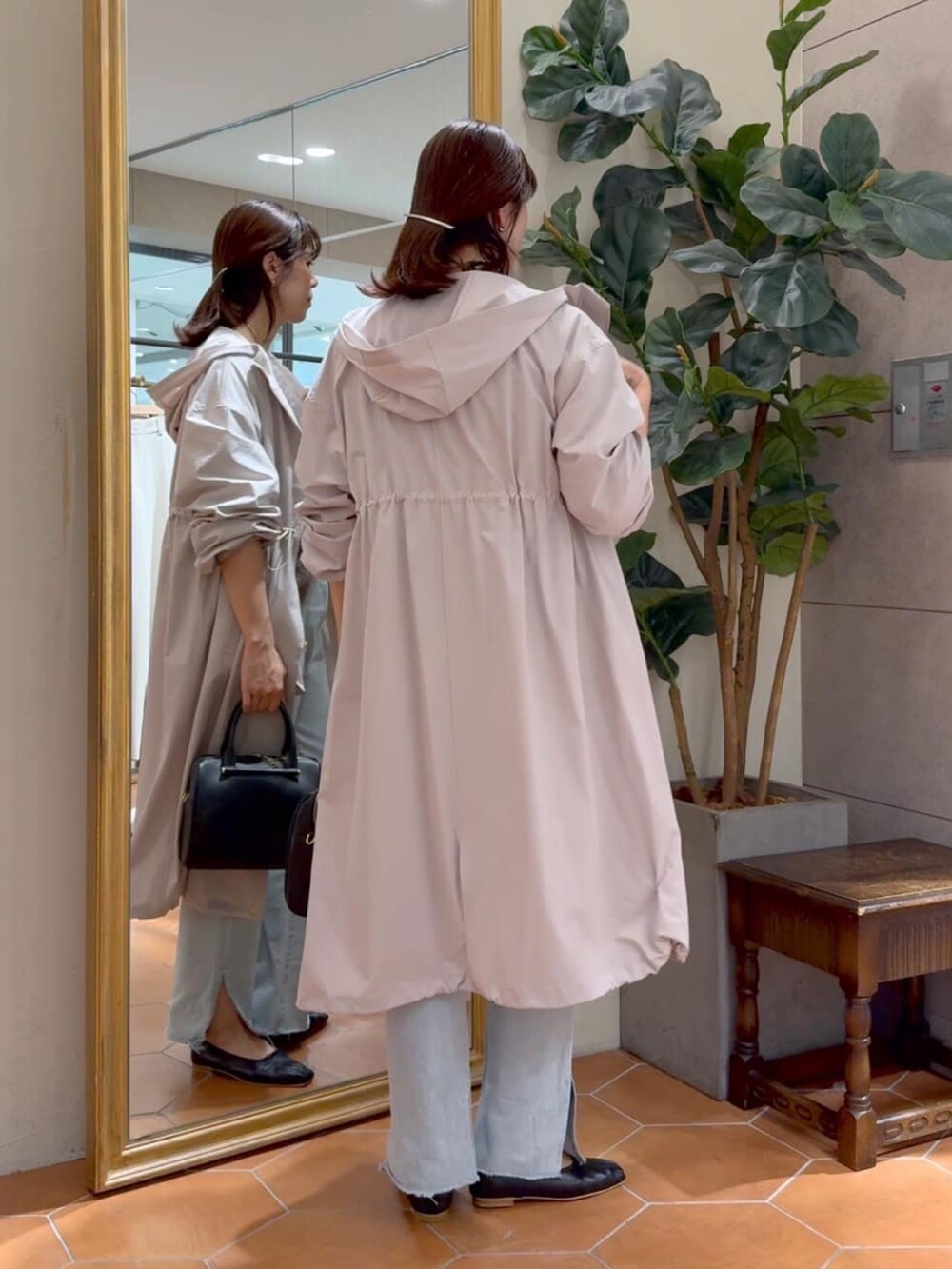 ブラウン系のニット/セーター、ベージュ系のモッズコート、ブラック系のボストンバッグを着用したレディースの秋コーディネートの3枚目の写真