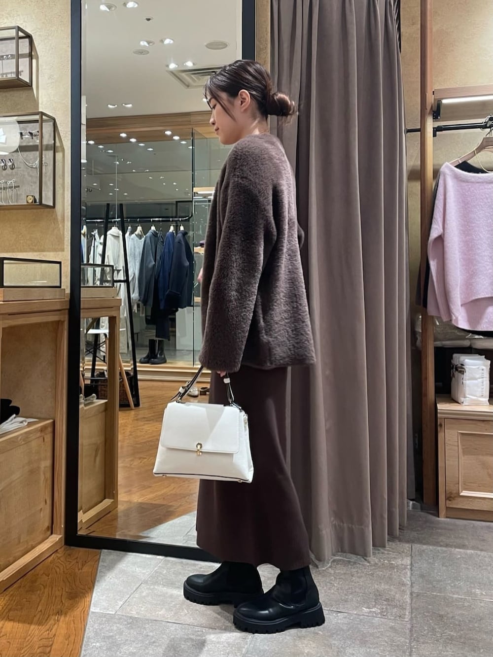 ブラウン系のカーディガン/ボレロ、ブラウン系のワンピース、ブラック系のブーツを着用したレディースの秋コーディネートの2枚目の写真