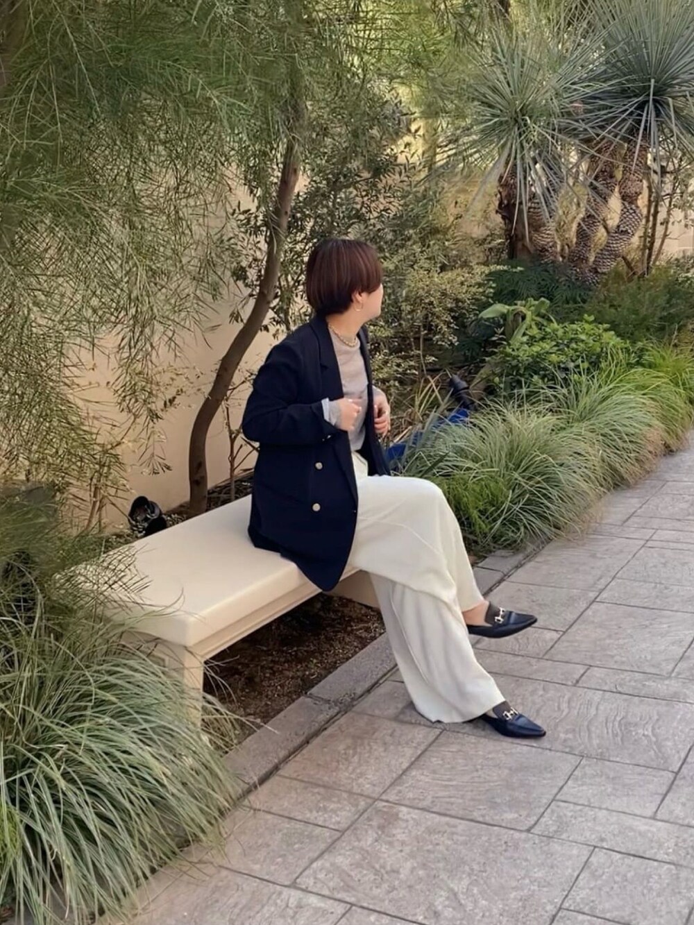 ブルー系のテーラードジャケット、グレー系のニット/セーター、ホワイト系のスラックスを着用したレディースの冬コーディネートの3枚目の写真