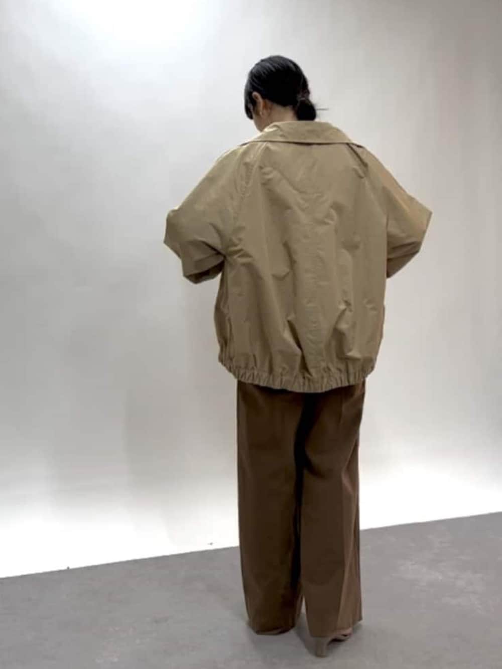 ホワイト系のニット/セーター、ベージュ系のブルゾン、ブラウン系のその他パンツを着用したレディースの春コーディネートの3枚目の写真