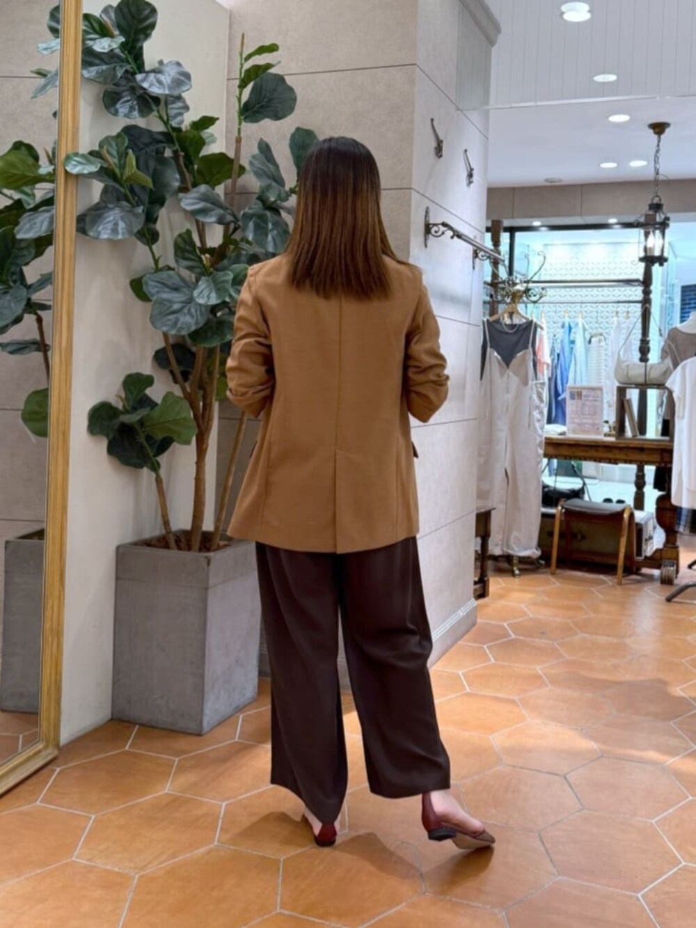 ベージュ系のTシャツ/カットソー、ブラック系のボストンバッグ、ブラウン系のテーラードジャケットを着用したレディースの夏コーディネートの4枚目の写真