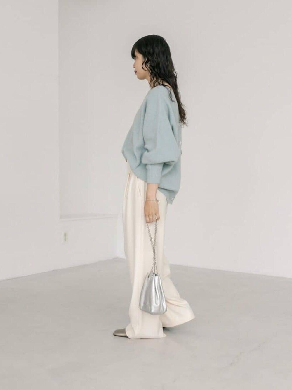 シルバー系のショルダーバッグ、ホワイト系のその他パンツ、ブルー系のカーディガン/ボレロを着用したレディースの冬コーディネートの2枚目の写真
