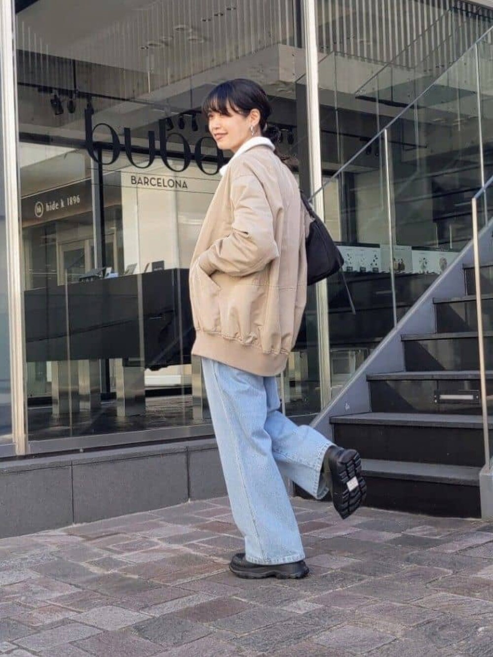 ブルー系のデニムパンツを着用したレディースの冬コーディネートの2枚目の写真