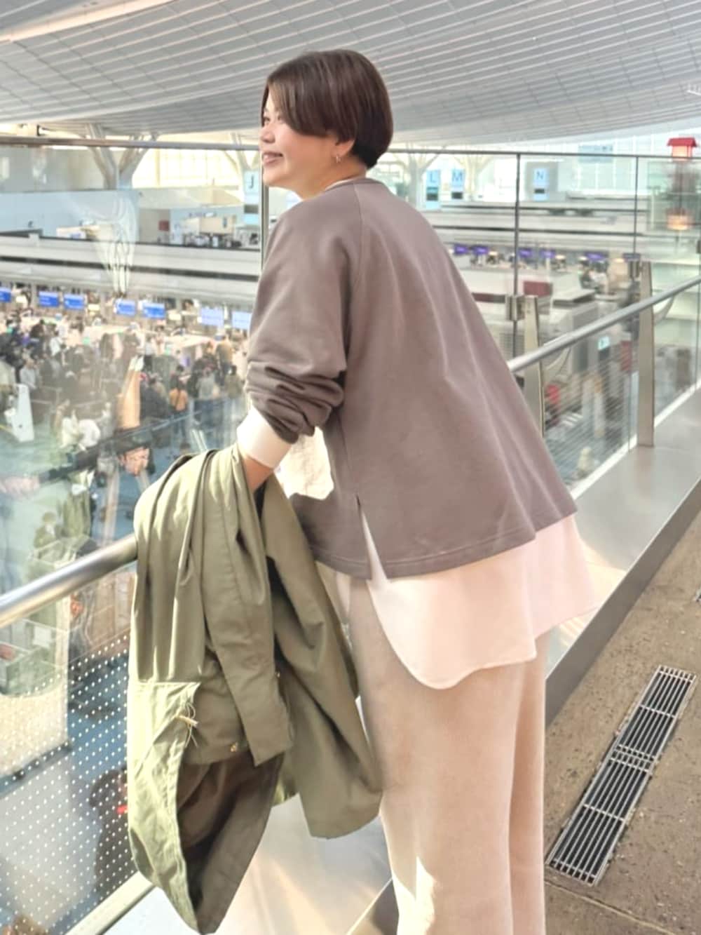 ホワイト系のTシャツ/カットソー、ホワイト系のスカート、グリーン系のその他アウターを着用したレディースの冬コーディネートの5枚目の写真