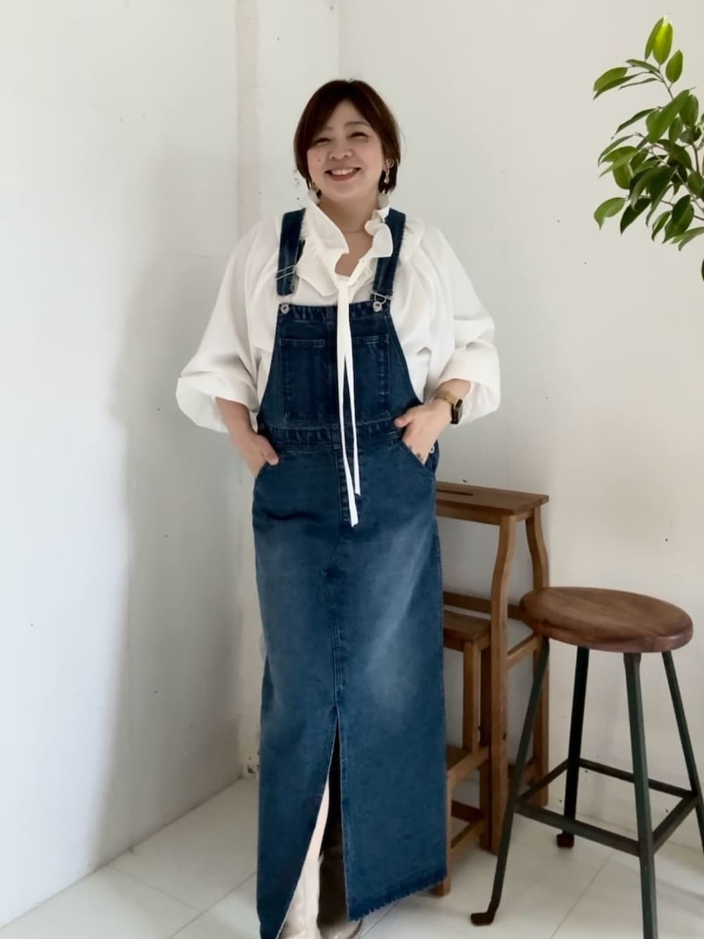 ブルー系のジャンパースカート、ホワイト系のシャツ/ブラウスを着用したレディースの冬コーディネートの3枚目の写真