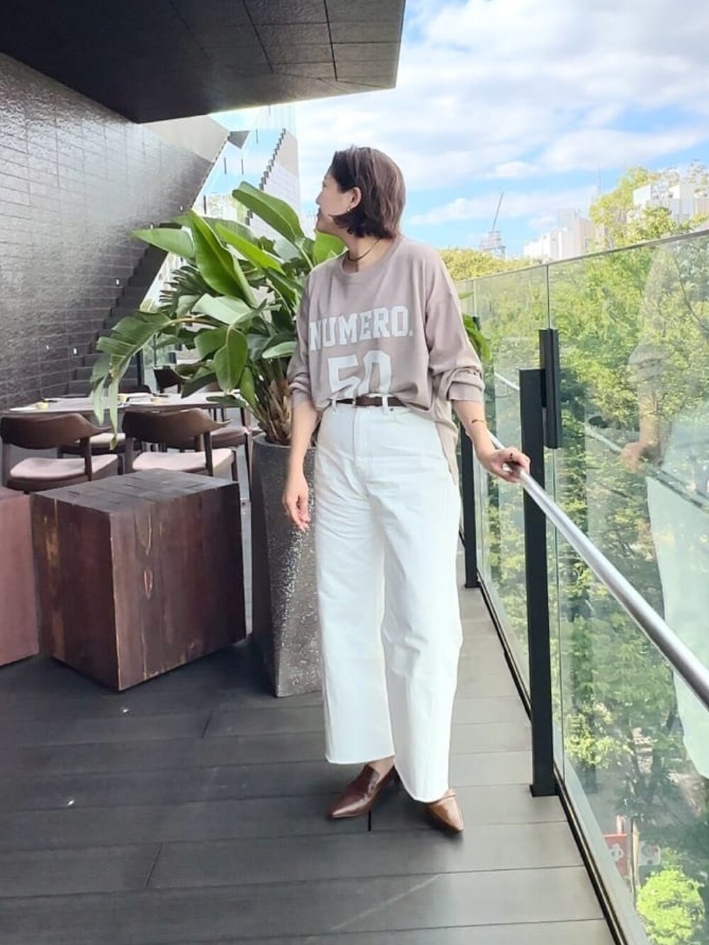 ベージュ系のニット/セーター、ホワイト系のデニムパンツ、ブラウン系のローファーを着用したレディースの秋コーディネートの2枚目の写真