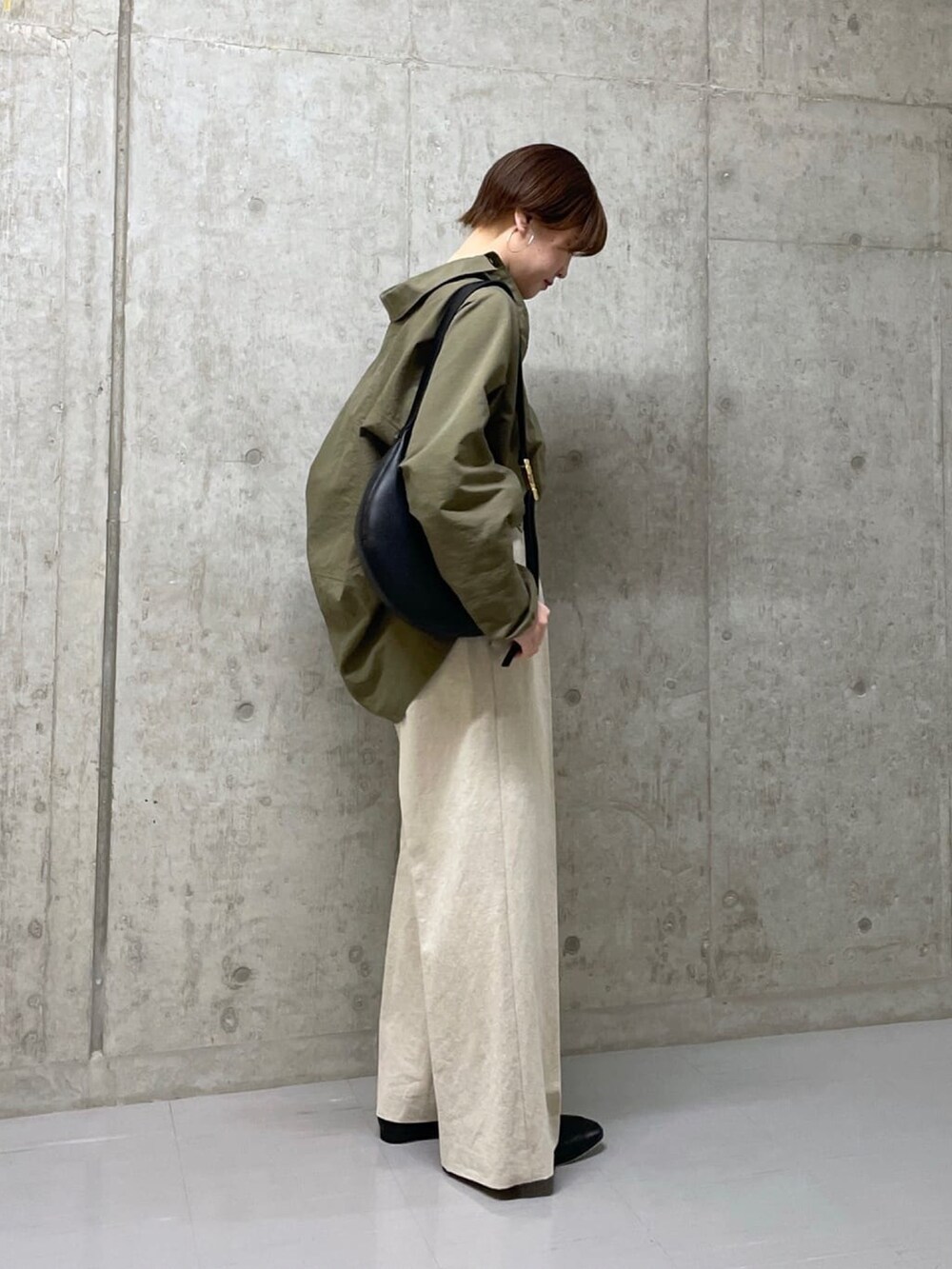 ブラック系のボディバッグ/ウエストポーチ、グリーン系のシャツ/ブラウス、ベージュ系のその他パンツを着用したレディースの春コーディネートの3枚目の写真