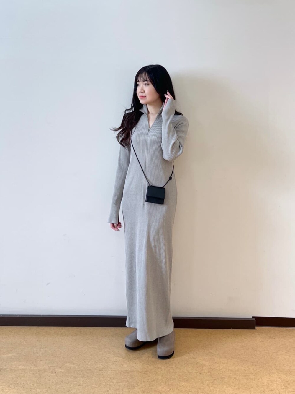 ブラック系のマウンテンパーカー、グレー系のワンピース、ブラック系のショルダーバッグを着用したレディースの春コーディネートの3枚目の写真