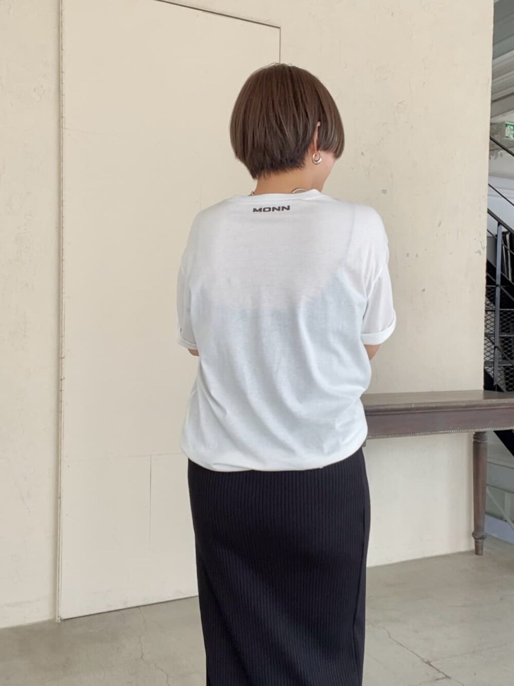 ブラック系のTシャツ/カットソー、ブラック系のスカート、ブラック系のサンダルを着用したレディースの夏コーディネートの4枚目の写真