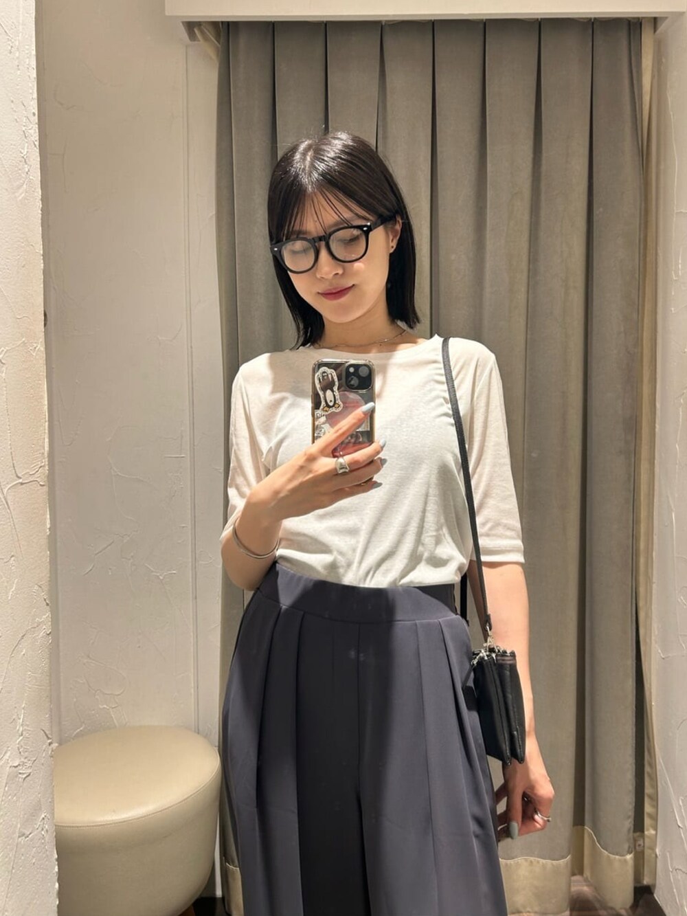 グレー系のスラックス、ホワイト系のTシャツ/カットソーを着用したレディースの夏コーディネートの2枚目の写真