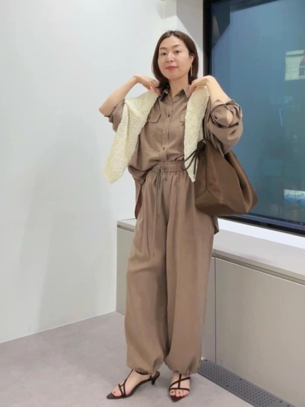 ブラウン系のその他パンツ、ブラウン系のシャツ/ブラウス、ブラウン系のトートバッグを着用したレディースの春コーディネートの2枚目の写真