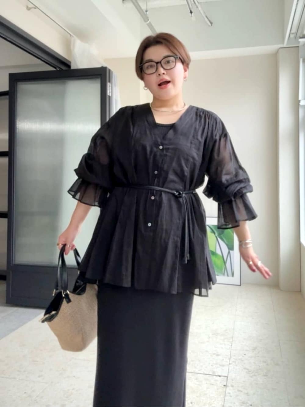 ブラック系のワンピース、ブラック系のサンダル、ブラック系のシャツ/ブラウスを着用したレディースの春コーディネートの4枚目の写真