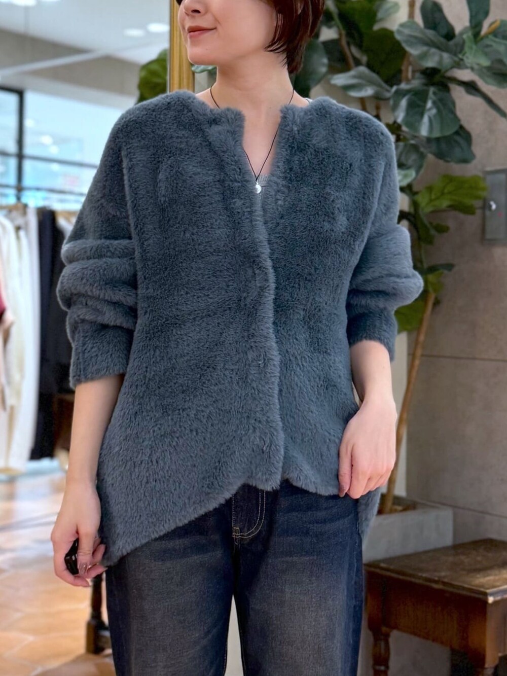 ブルー系のカーディガン/ボレロ、ブルー系のデニムパンツ、ブラック系のショルダーバッグを着用したレディースの秋コーディネートの5枚目の写真