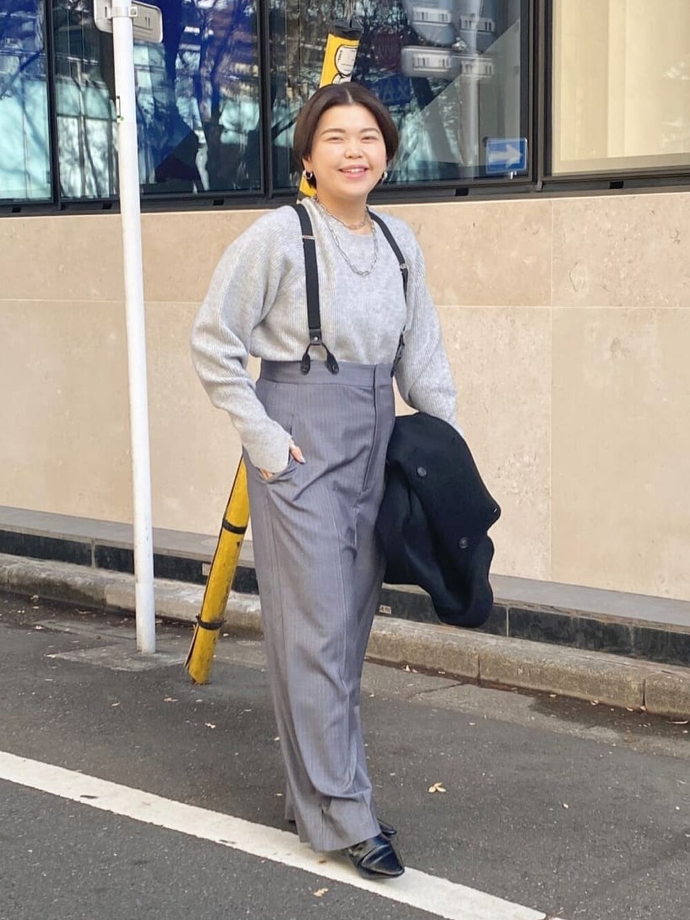 グレー系のニット/セーター、グレー系のパンツを着用したレディースの冬コーディネートの2枚目の写真