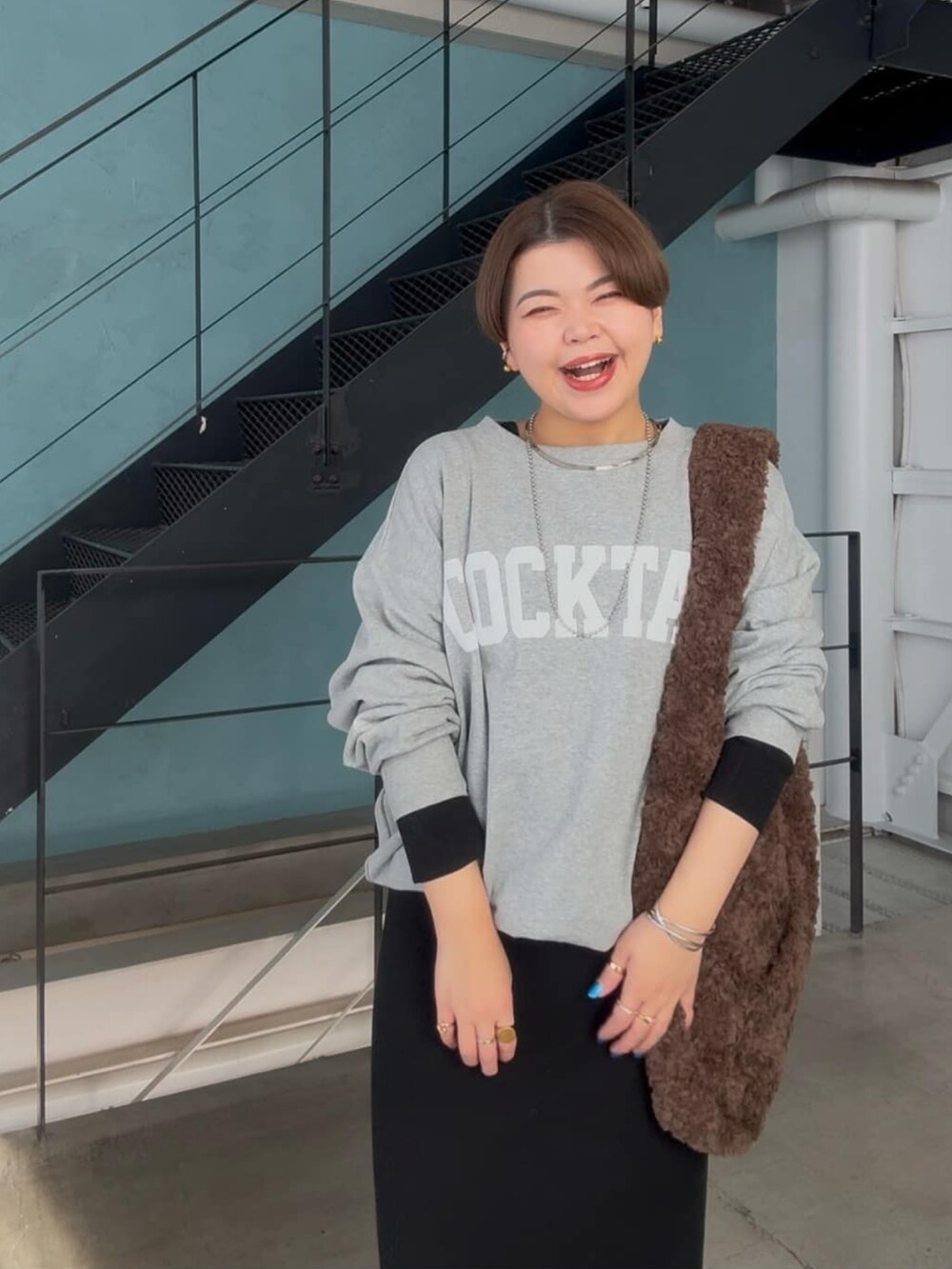 グレー系のスウェット、ブラック系のワンピースを着用したレディースの冬コーディネートの4枚目の写真