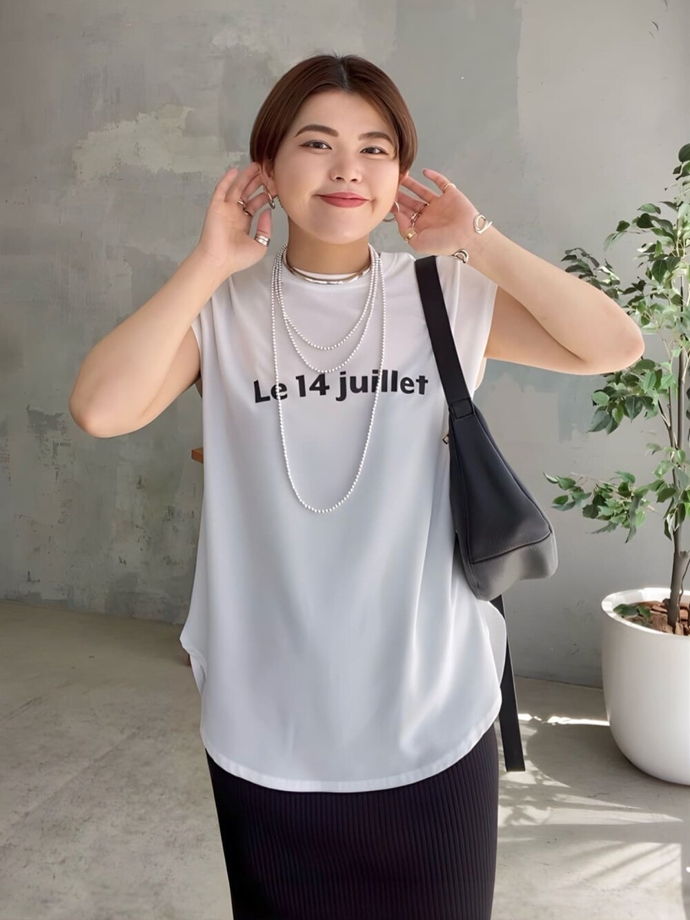 ホワイト系のシャツ/ブラウス、ブラック系のスカート、シルバー系のサンダルを着用したレディースの夏コーディネートの3枚目の写真