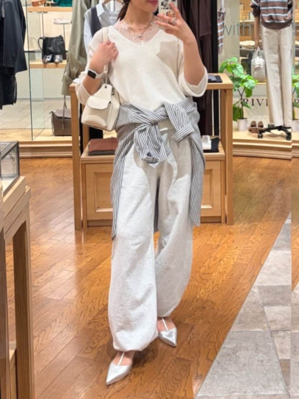 グレー系のスウェットパンツ、ホワイト系のニット/セーター、ホワイト系のショルダーバッグを着用したレディースの春コーディネートの3枚目の写真