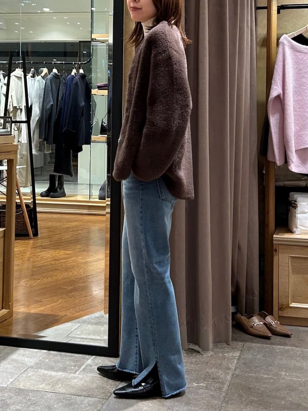 ホワイト系のニット/セーター、ブラウン系のカーディガン/ボレロ、ブルー系のデニムパンツを着用したレディースの秋コーディネートの2枚目の写真