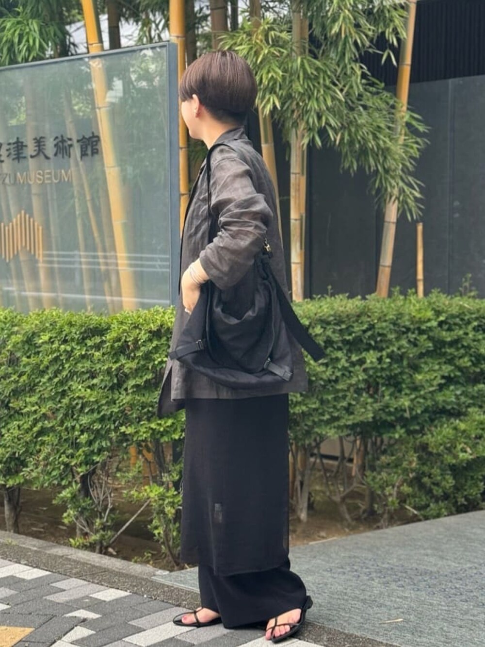 ブラック系のワンピース、ブラック系のスラックス、グレー系のテーラードジャケットを着用したレディースの夏コーディネートの2枚目の写真