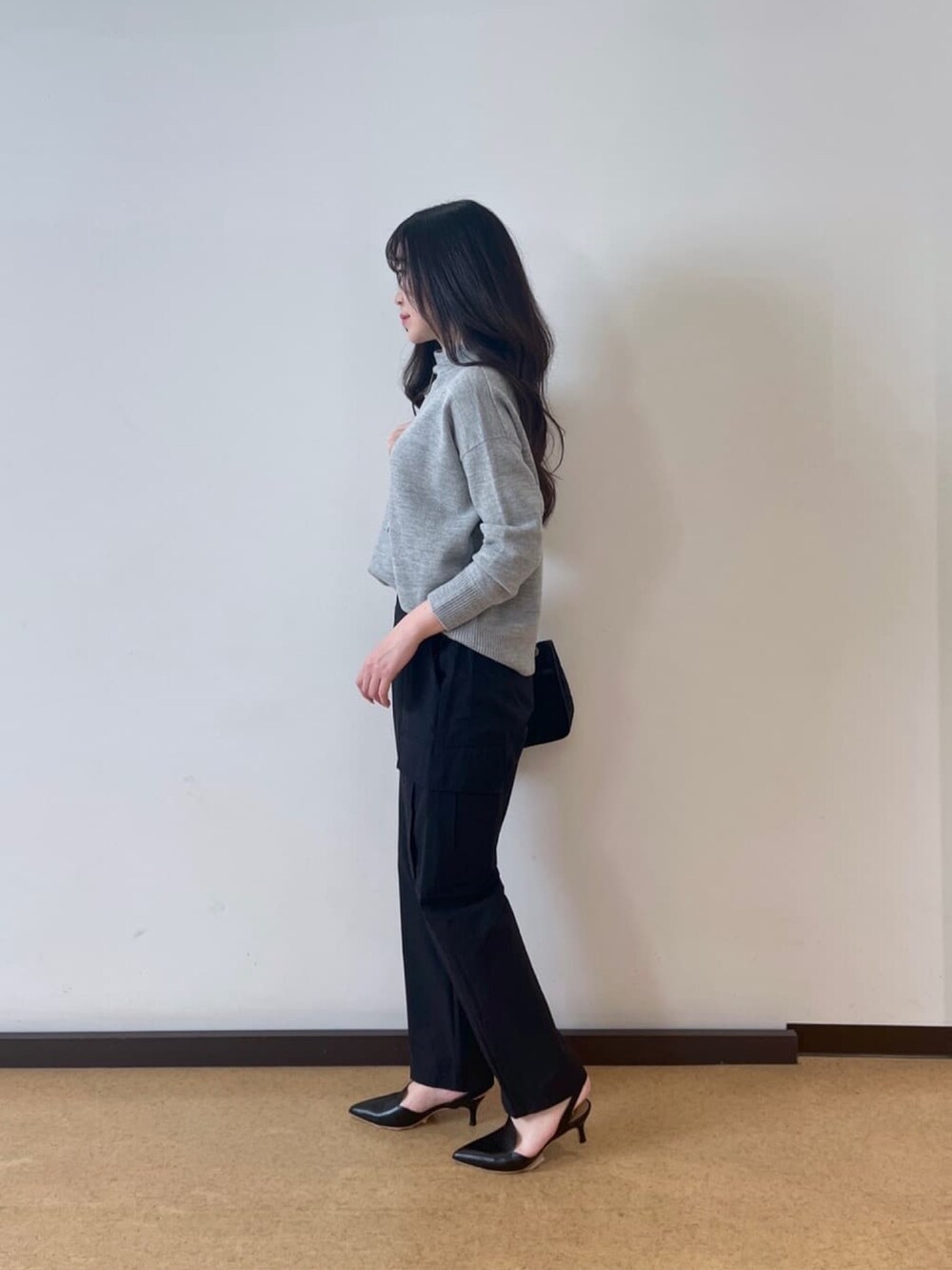 ブラック系のカーゴパンツ、グレー系のニット/セーター、ブラック系のパンプスを着用したレディースの秋コーディネートの2枚目の写真