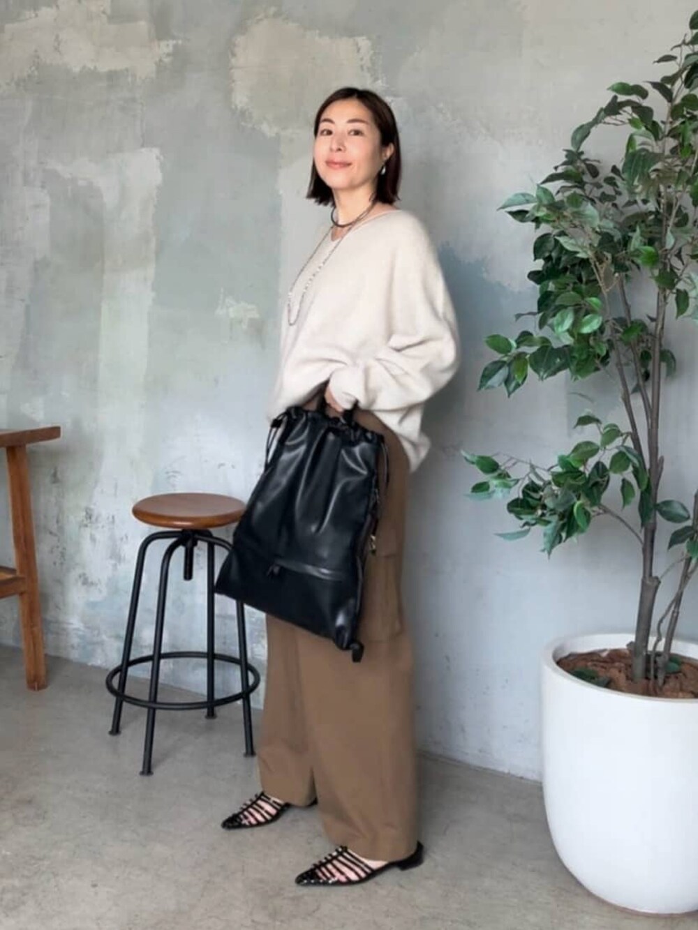 ブラウン系のカーゴパンツ、ブラック系のショルダーバッグ、ブラック系のサンダルを着用したレディースの夏コーディネートの2枚目の写真