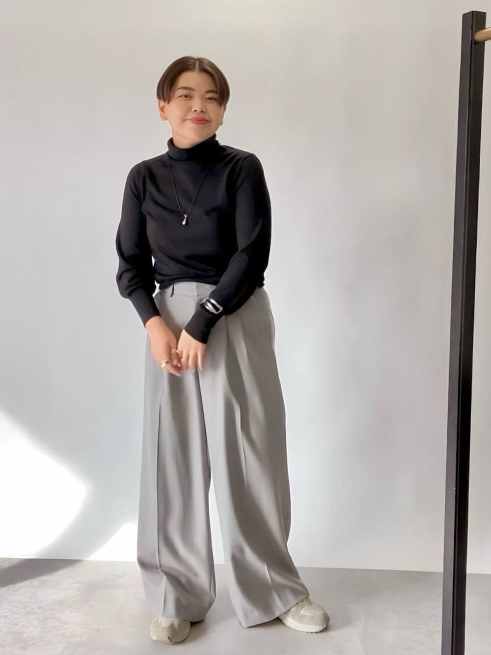 ブラック系のニット/セーター、グレー系のその他パンツを着用したレディースの冬コーディネートの2枚目の写真