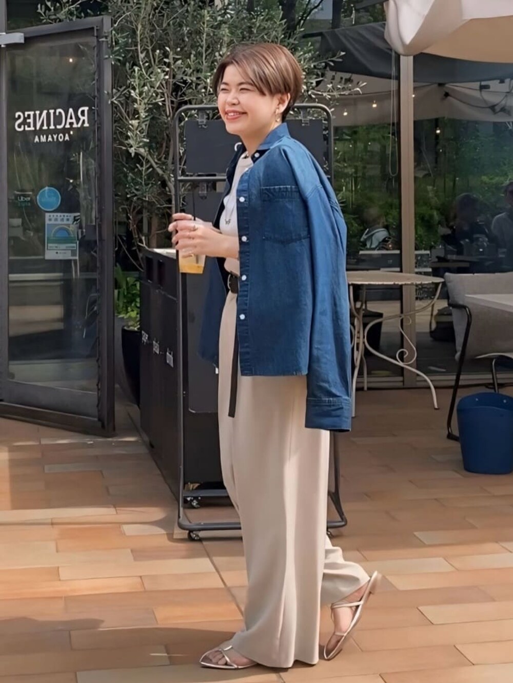 グレー系のTシャツ/カットソー、ブルー系のスラックス、シルバー系のサンダルを着用したレディースの春コーディネートの4枚目の写真