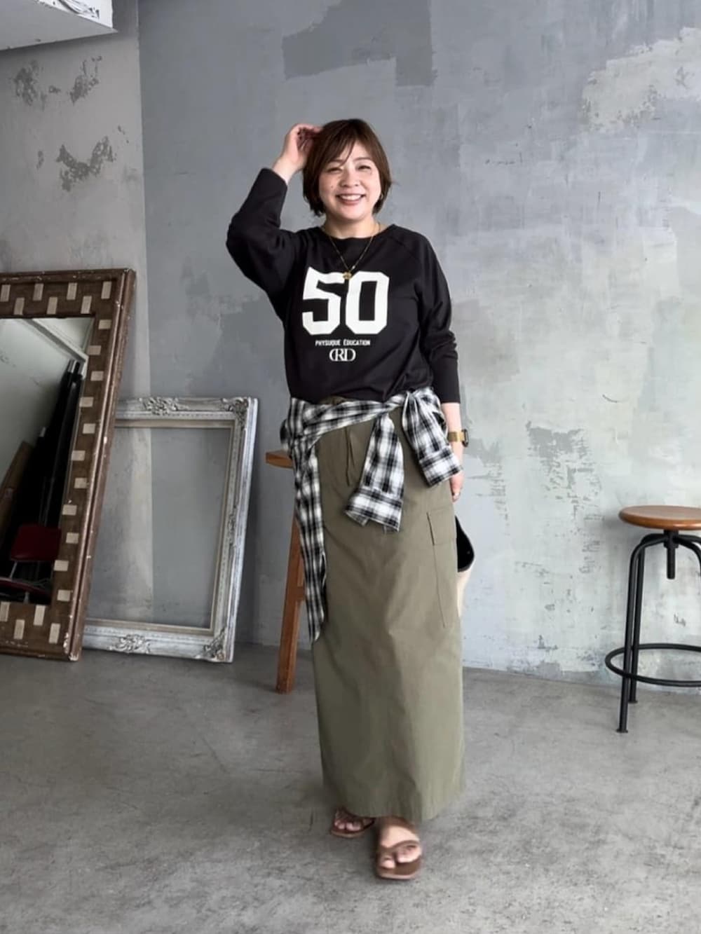 ブラック系のシャツ/ブラウス、ブラック系のハンドバッグ、グレー系のTシャツ/カットソーを着用したレディースの夏コーディネートの2枚目の写真