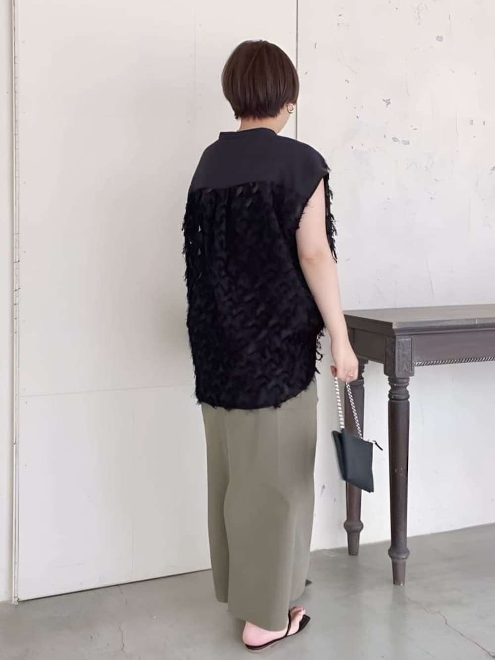 ブラック系のシャツ/ブラウス、ブラック系のショルダーバッグ、グリーン系のスカートを着用したレディースの夏コーディネートの4枚目の写真