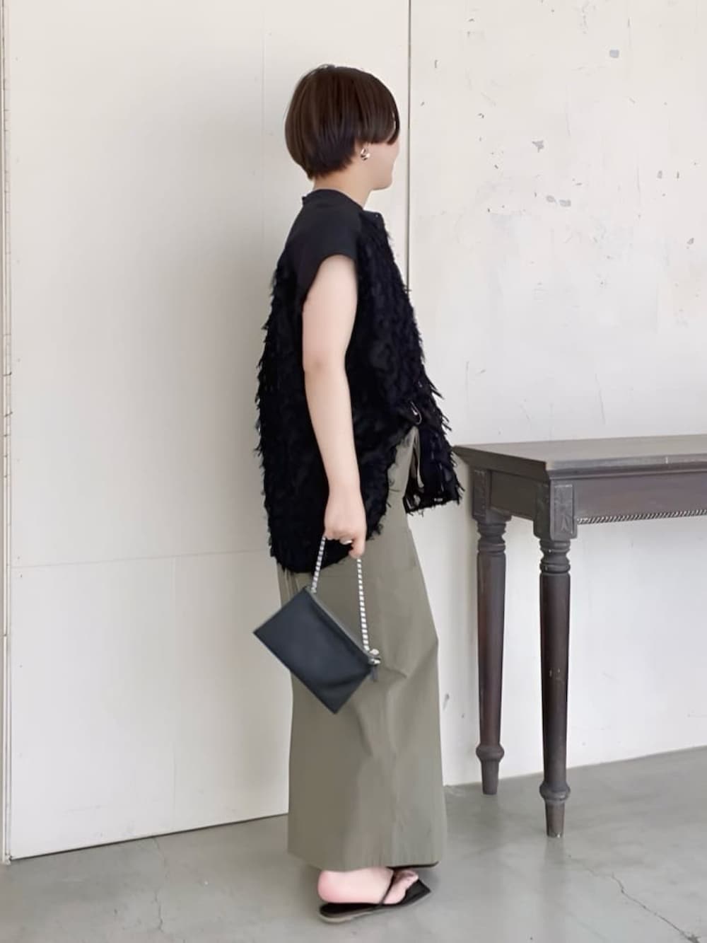 ブラック系のシャツ/ブラウス、ブラック系のショルダーバッグ、グリーン系のスカートを着用したレディースの夏コーディネートの3枚目の写真