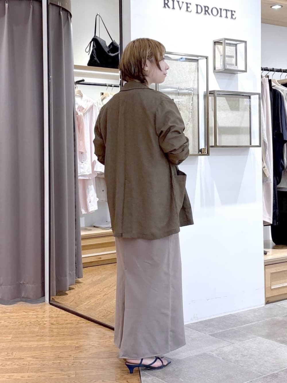 ホワイト系のTシャツ/カットソー、ブラウン系のテーラードジャケット、ブルー系のサンダルを着用したレディースの春コーディネートの3枚目の写真