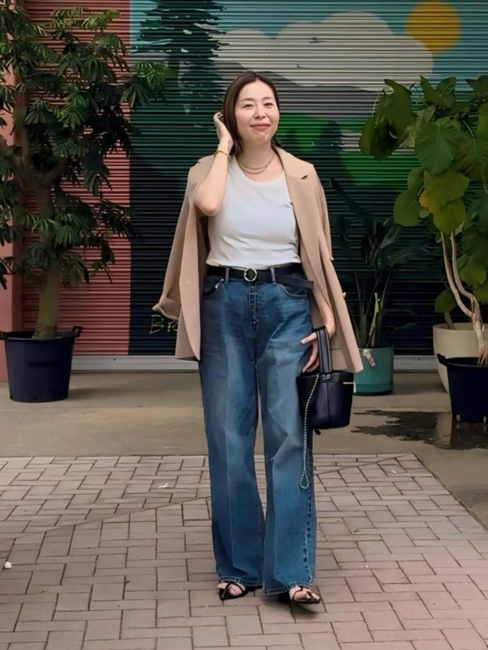 ブルー系のデニムパンツ、ホワイト系のTシャツ/カットソー、イエロー系のテーラードジャケットを着用したレディースの秋コーディネートの2枚目の写真