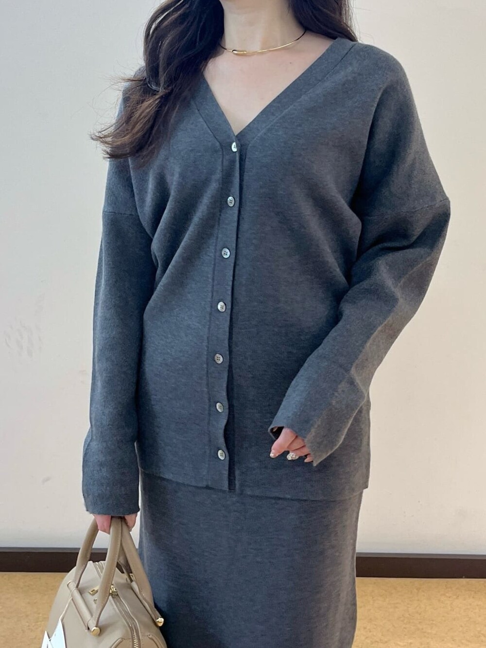 グレー系のカーディガン/ボレロ、グレー系のスカート、ベージュ系のブーツを着用したレディースの秋コーディネートの5枚目の写真