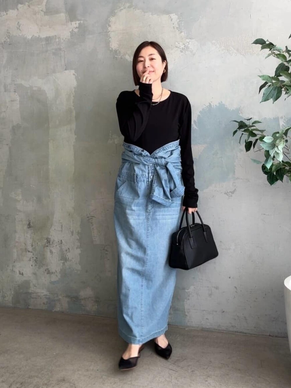 ブラック系のTシャツ/カットソー、ブラック系のベスト、ブルー系のシャツワンピースを着用したレディースの冬コーディネートの5枚目の写真