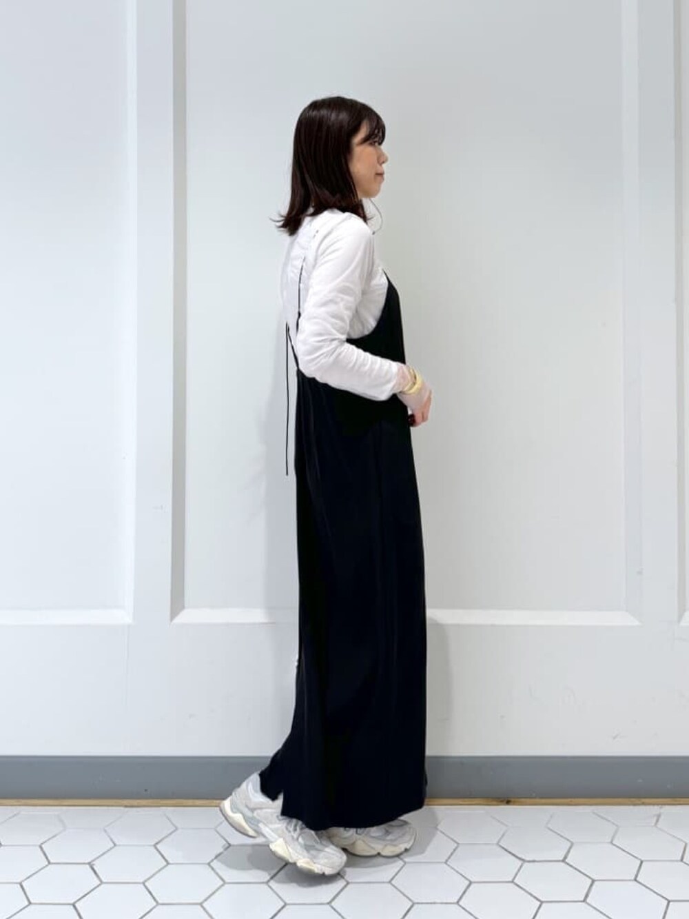 ベージュ系のTシャツ/カットソー、ブラック系のワンピースを着用したレディースの冬コーディネートの2枚目の写真