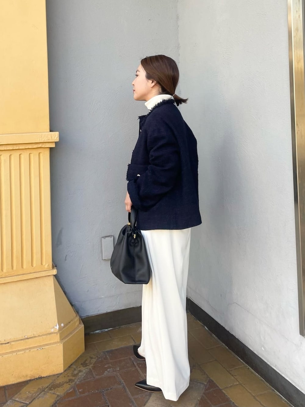 ブルー系のノーカラージャケット、ホワイト系のスラックス、ホワイト系のニット/セーターを着用したレディースの冬コーディネートの2枚目の写真