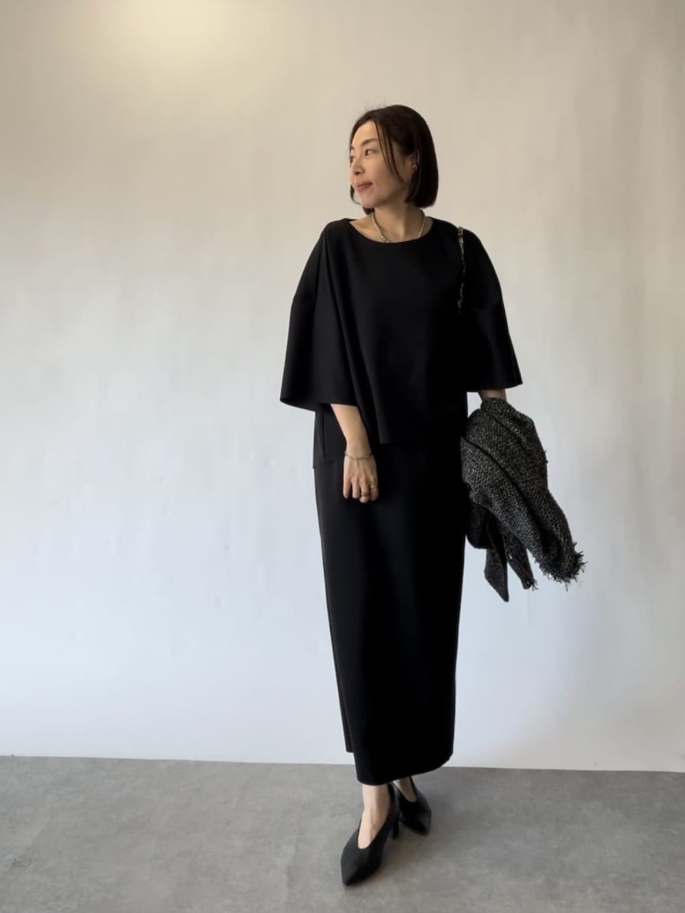 ブラック系のTシャツ/カットソー、ブラック系のカーディガン/ボレロ、ブラック系のスカートを着用したレディースの冬コーディネートの3枚目の写真