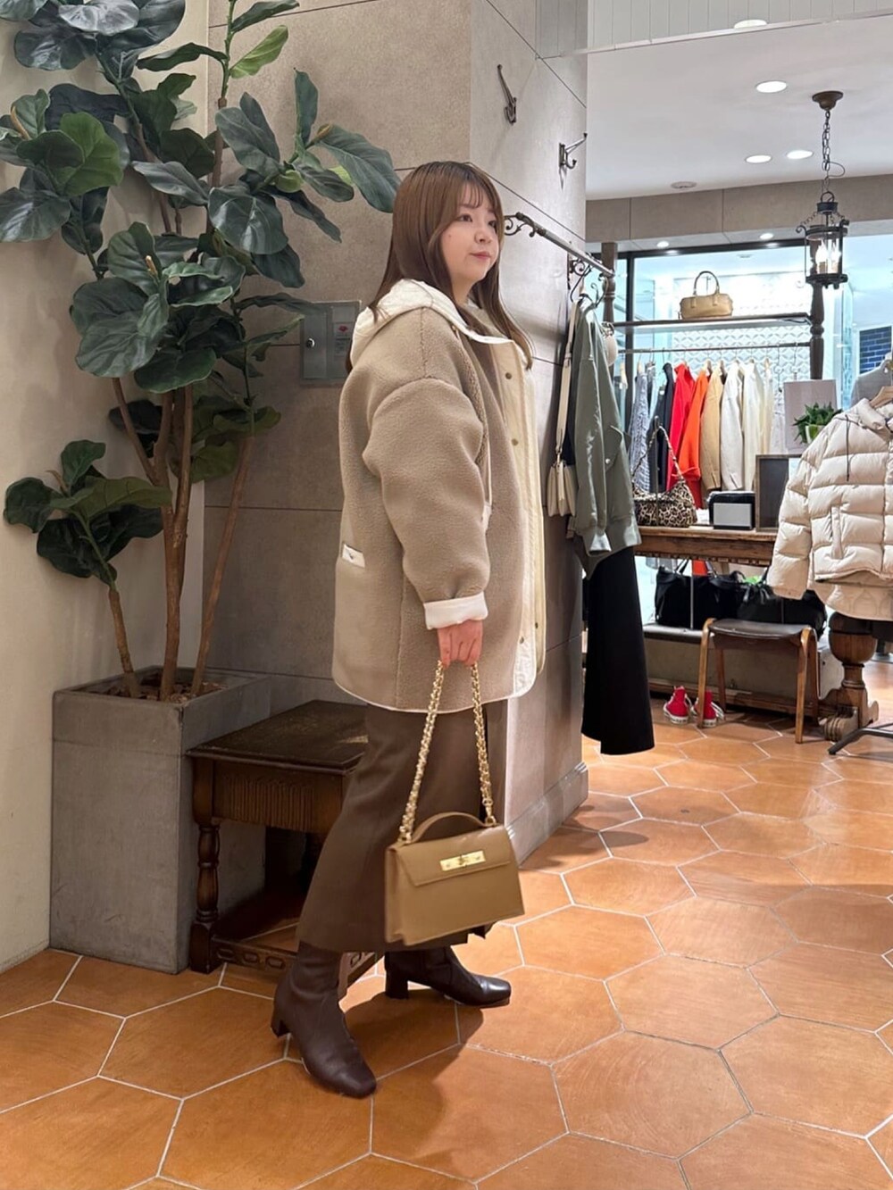 ベージュ系のその他アウター、ブラウン系のスカート、ブラウン系のブーツを着用したレディースの冬コーディネートの2枚目の写真