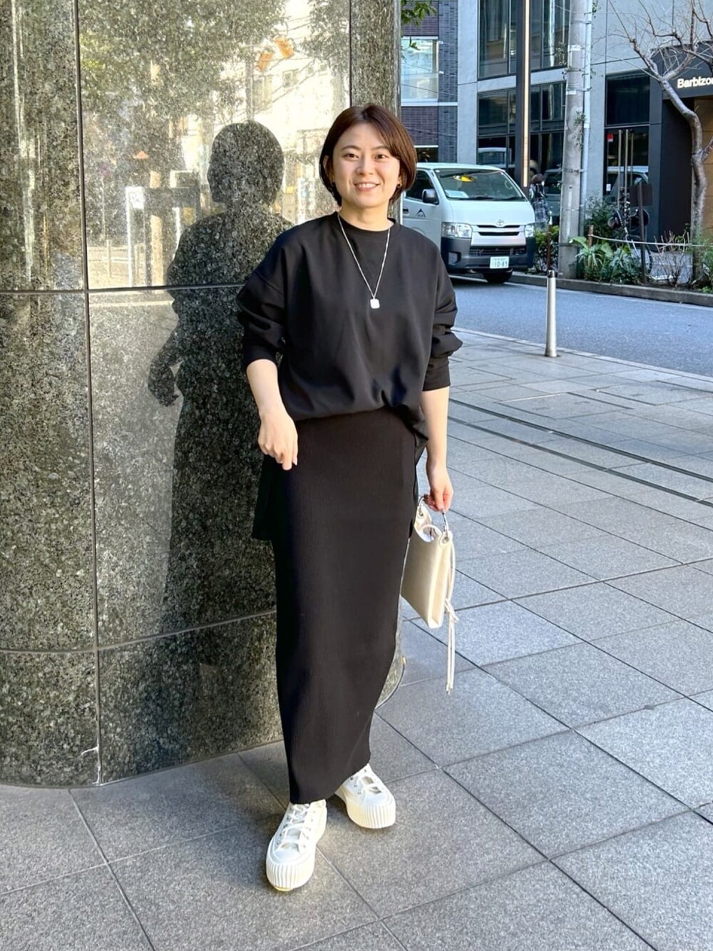 ブラック系のTシャツ/カットソー、ベージュ系のテーラードジャケット、ブラック系のスカートを着用したレディースの春コーディネートの4枚目の写真