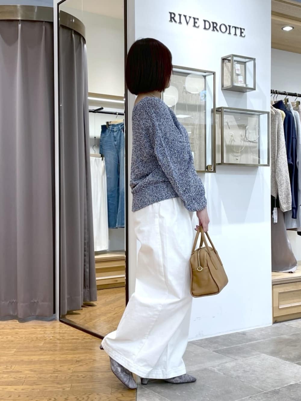 イエロー系のボストンバッグ、ホワイト系のデニムパンツ、ブルー系のニット/セーターを着用したレディースの春コーディネートの2枚目の写真