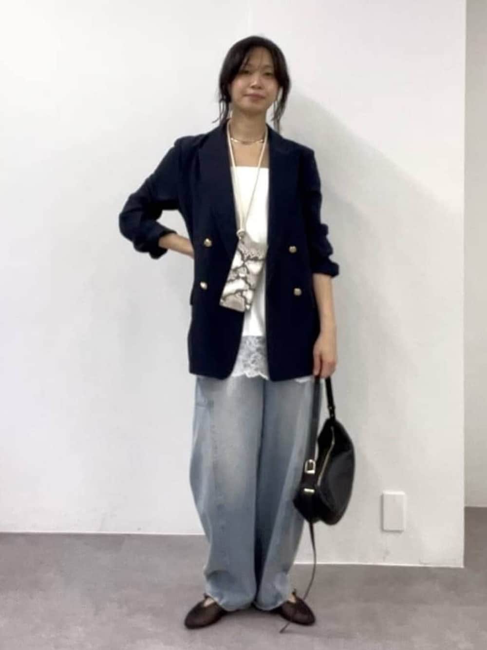 ホワイト系のキャミソール、ブルー系のデニムパンツ、ブラック系のその他シューズを着用したレディースの冬コーディネートの4枚目の写真