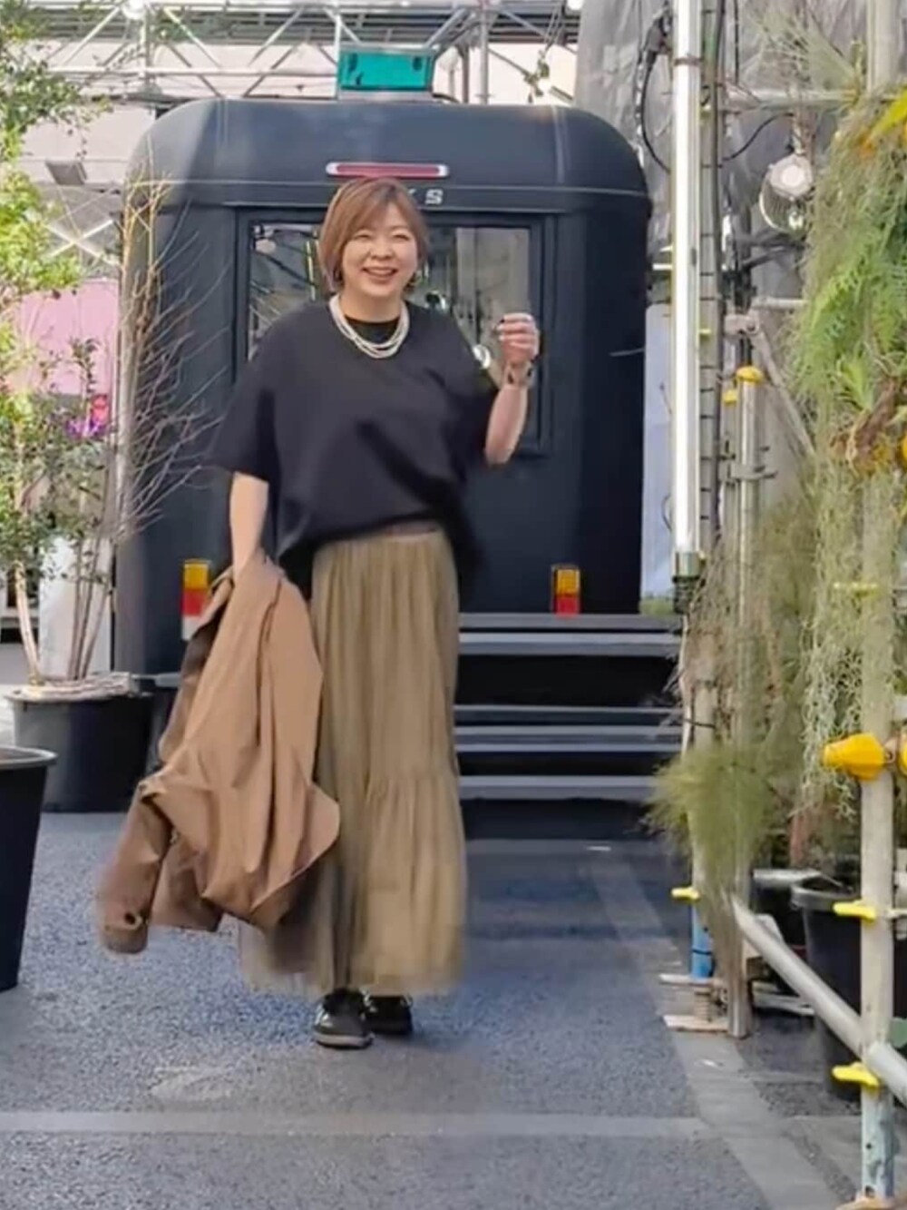 グレー系のスカート、ホワイト系のTシャツ/カットソーを着用したレディースの春コーディネートの2枚目の写真