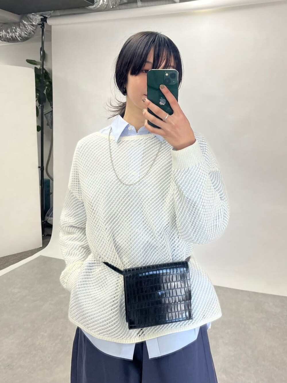 ホワイト系のニット/セーター、ブラック系のショルダーバッグ、ブルー系のシャツ/ブラウスを着用したレディースの冬コーディネートの3枚目の写真