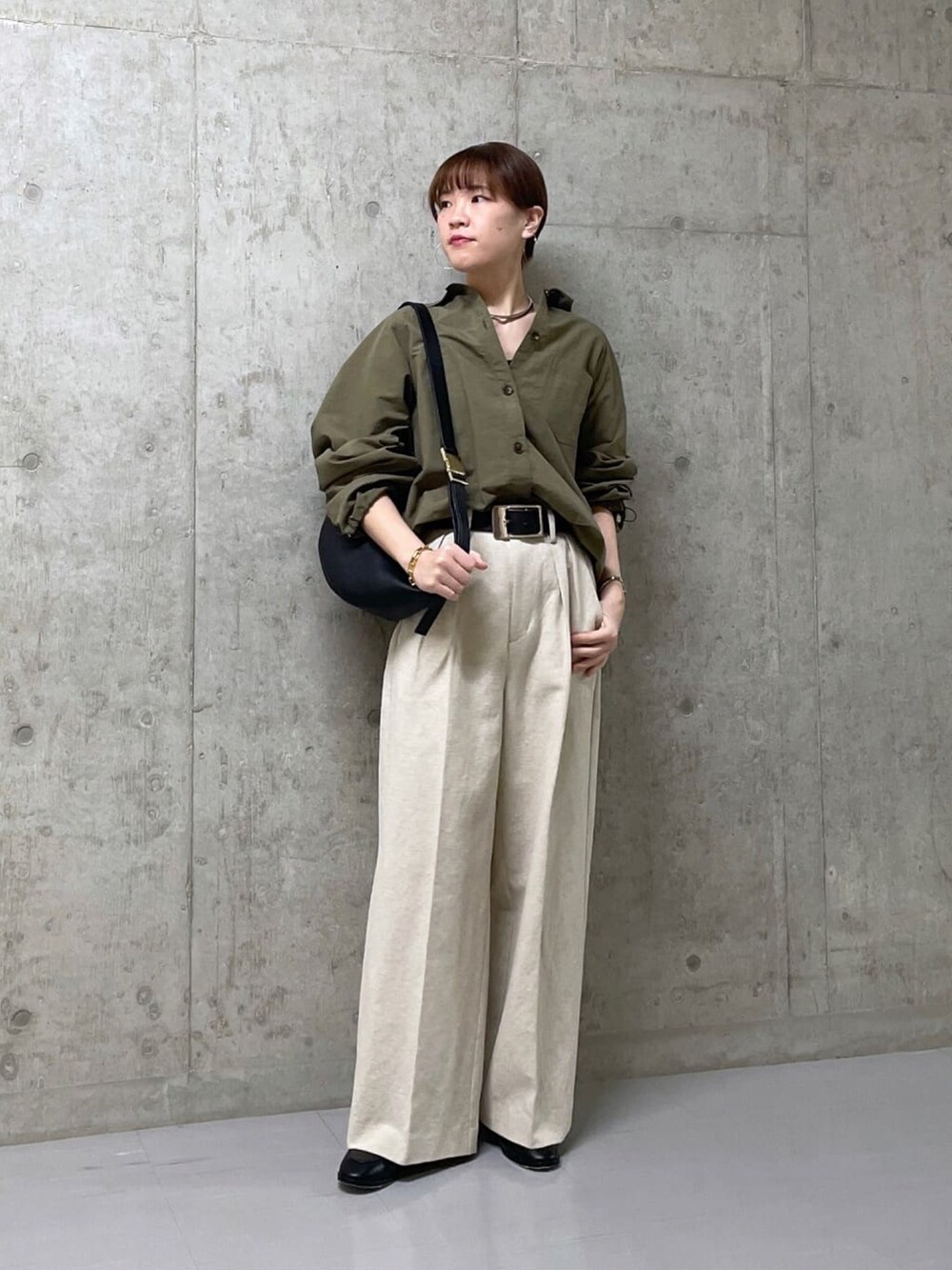 ブラック系のボディバッグ/ウエストポーチ、グリーン系のシャツ/ブラウス、ベージュ系のその他パンツを着用したレディースの春コーディネートの2枚目の写真