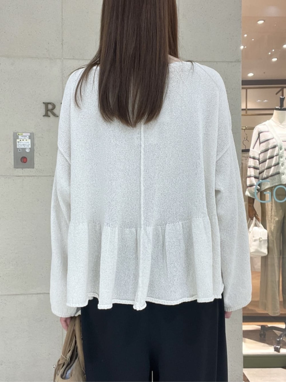 ベージュ系のトートバッグ、ブラウン系のその他シューズ、ホワイト系のニット/セーターを着用したレディースの春コーディネートの6枚目の写真