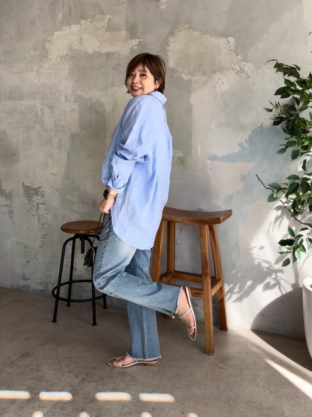 ブルー系のシャツ/ブラウス、ブルー系のデニムパンツ、シルバー系のサンダルを着用したレディースの春コーディネートの2枚目の写真